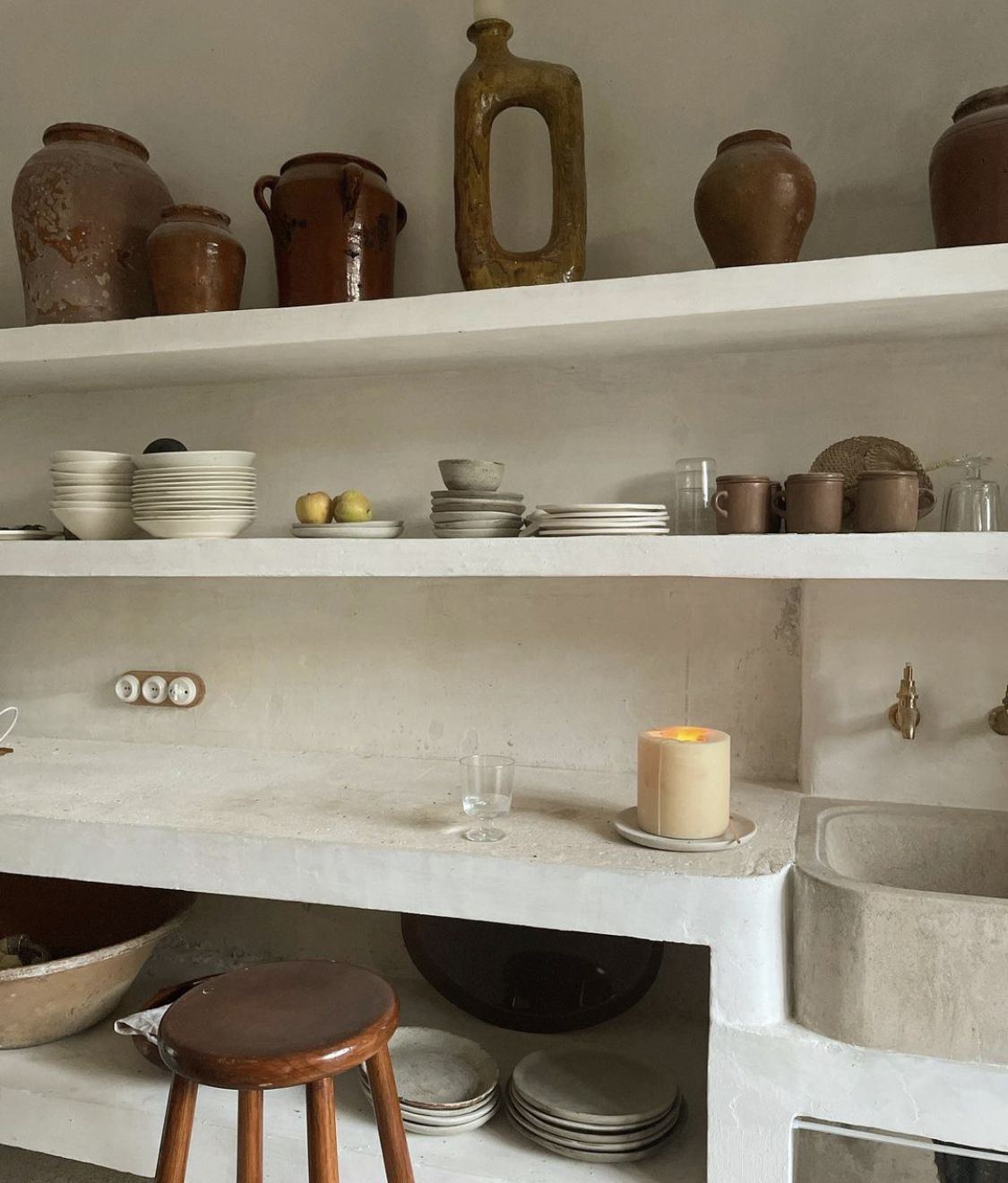 Cocina encalada con vasijas de barro y vajilla